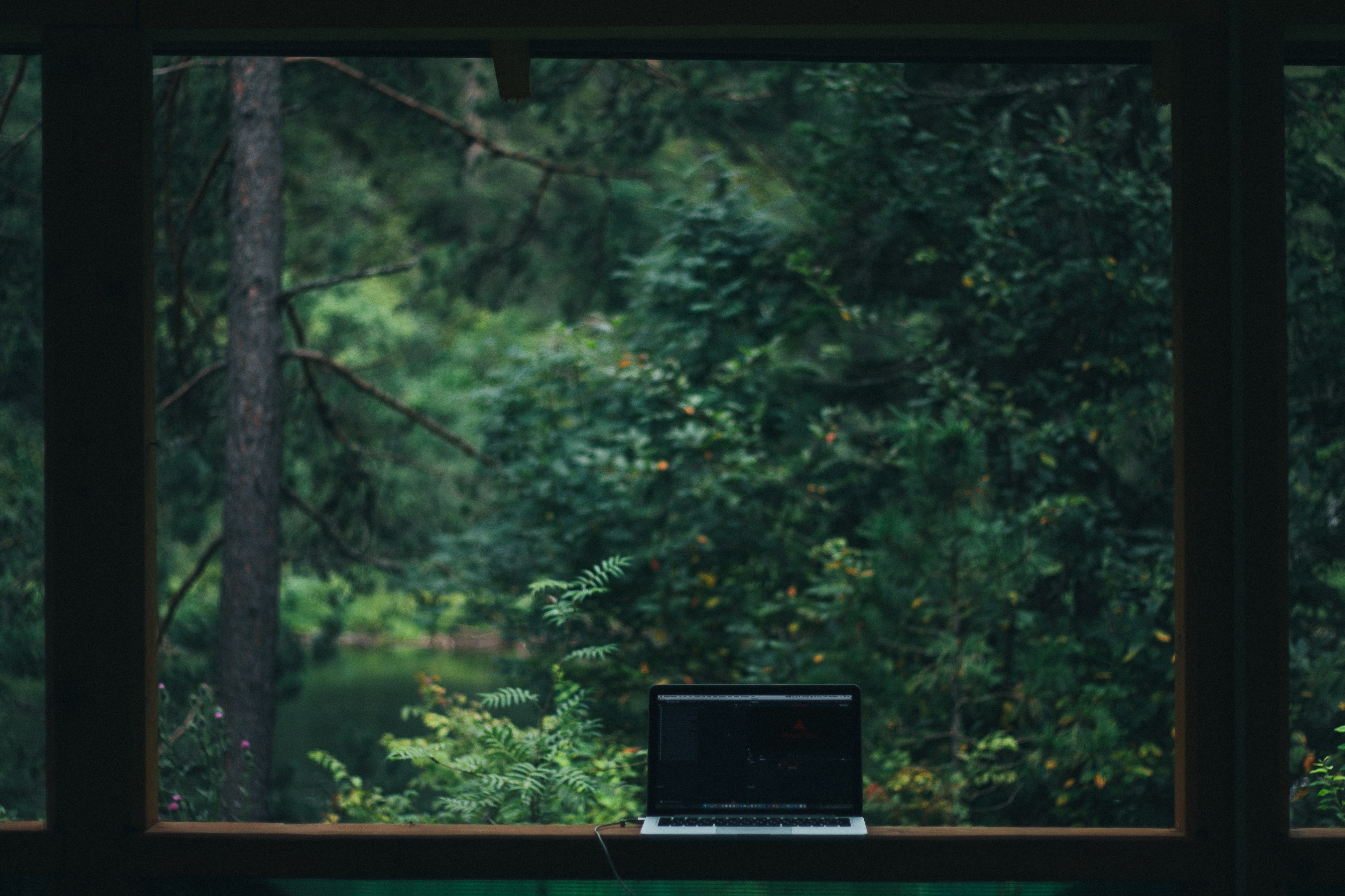 Laptop sitting on window with picturesque view