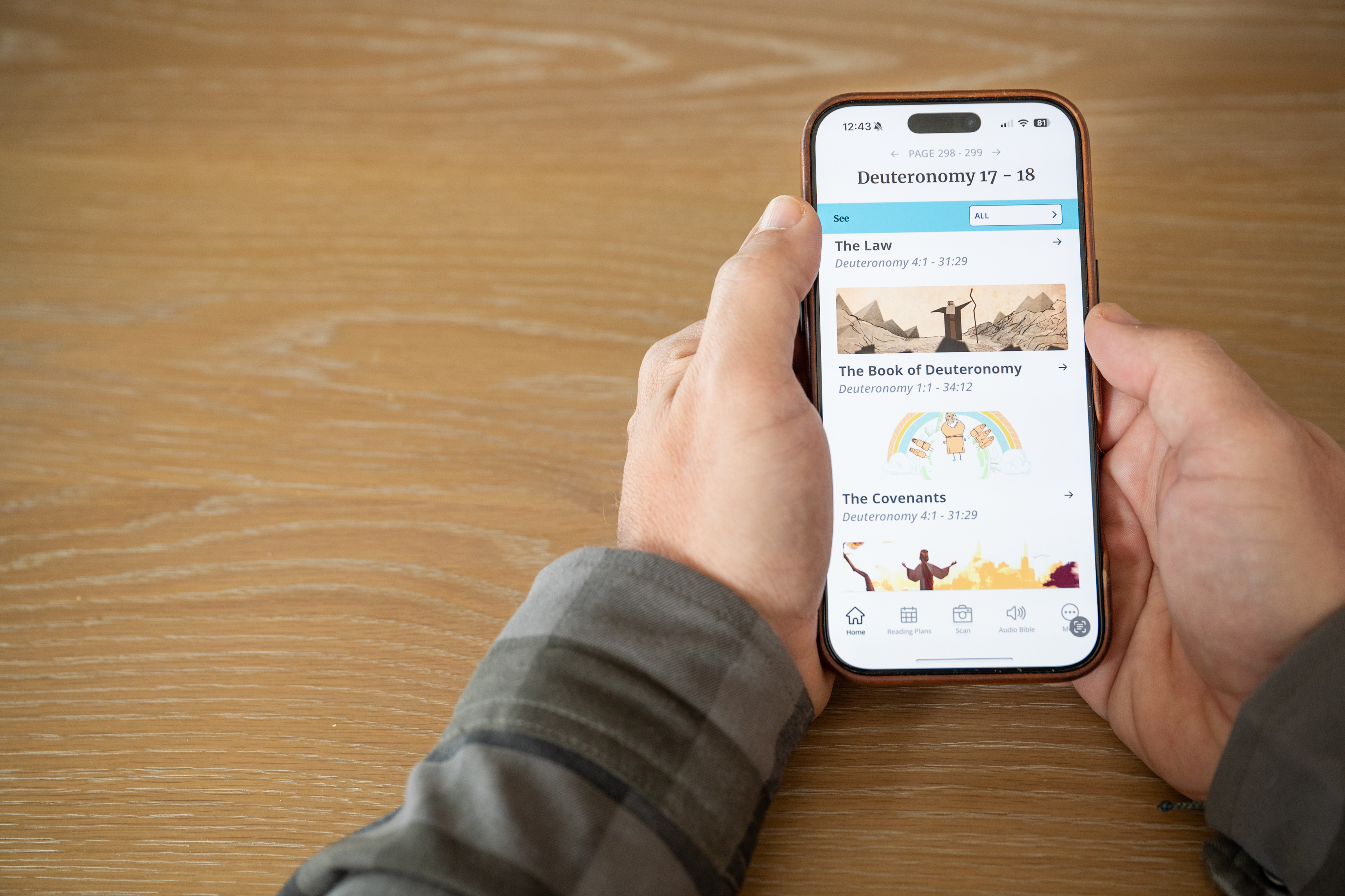 Hands holding a phone showing the Filament Bible app