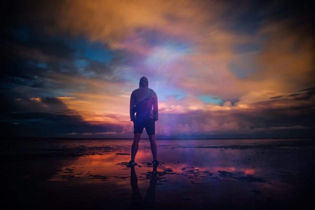 God offers hope in all situations, especially when forgiving our sin. A young man stands on a wet beach with a moody, colorful sky reflected on the still water. God offers hope in all situations, especially when forgiving our sin. A young man stands on a wet beach with a moody, colorful sky reflected on the still water.