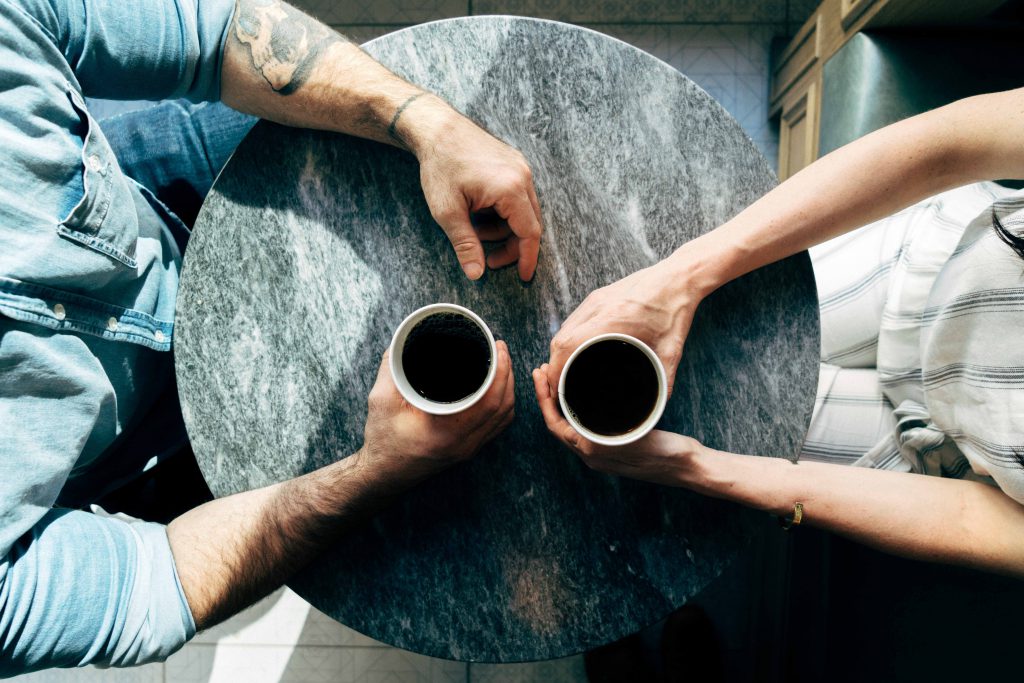An older man and a younger woman meet for coffee and to talk about their spiritual lives, an example of mentorship. An older man and a younger woman meet for coffee and to talk about their spiritual lives, an example of mentorship.