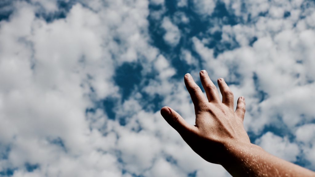 Lament prayers offer us relief. A hand reaches up to a blue sky with clouds. Lament prayers offer us relief. A hand reaches up to a blue sky with clouds.